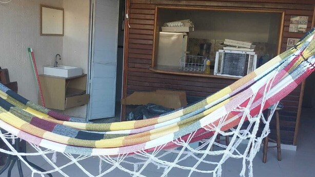 Una hamaca en una habitación con techo de madera y ventana.