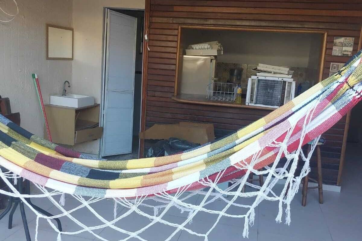 A hammock in a room with a wooden ceiling and a window.