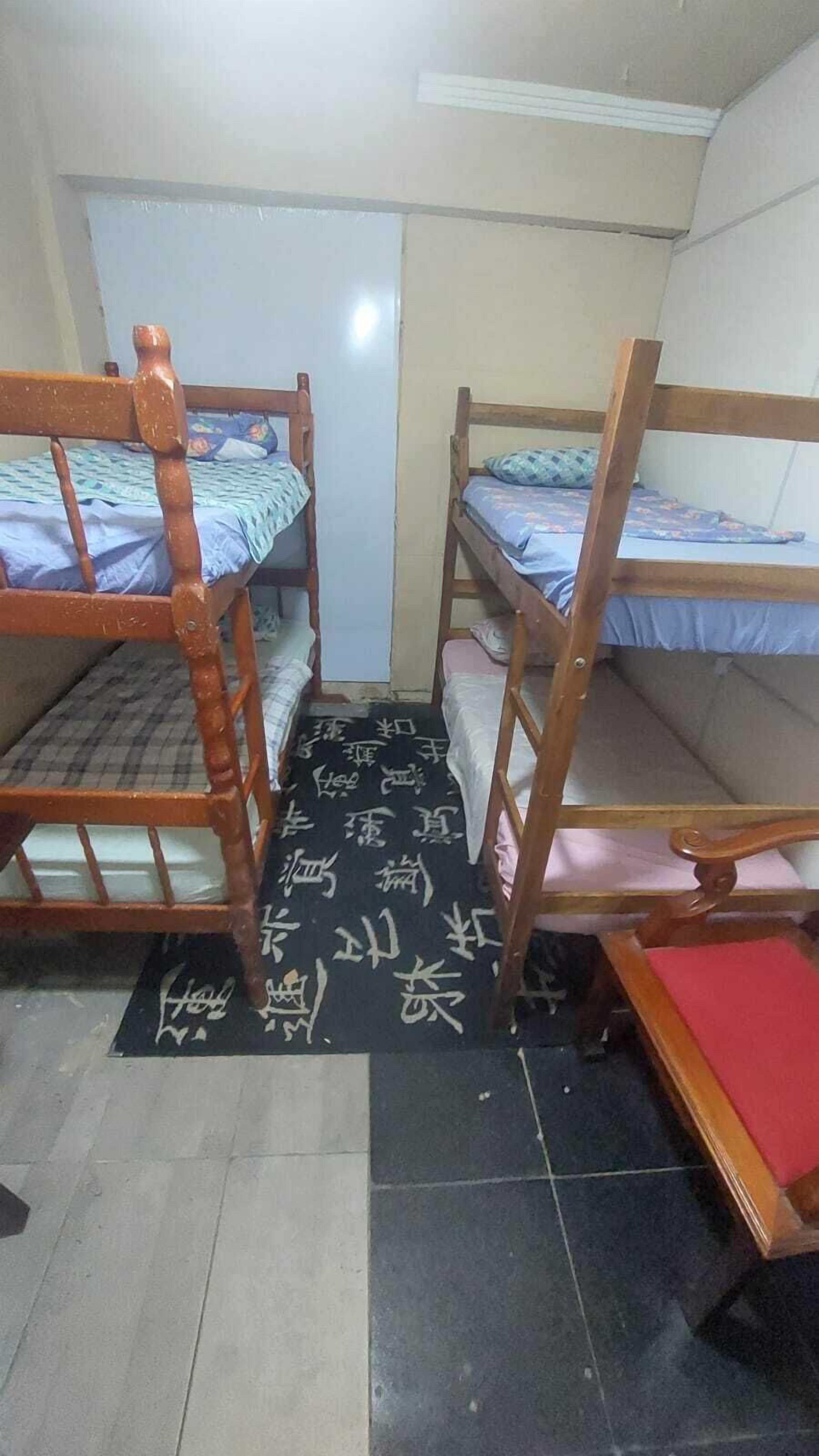 Un dormitorio con dos literas, un escritorio pequeño y una puerta.