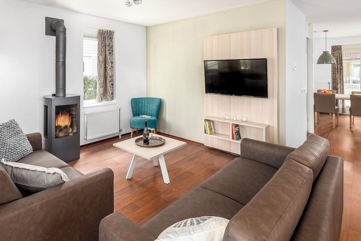 A modern living room with a fireplace, a television, and comfortable seating.