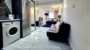 A compact living space with a kitchen, a sofa, and a bed. - Seaside Bliss Apartment for Style and Comfort (Cleethorpes)