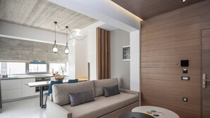 A modern living room with a sofa, a coffee table, and a kitchen area in the background.