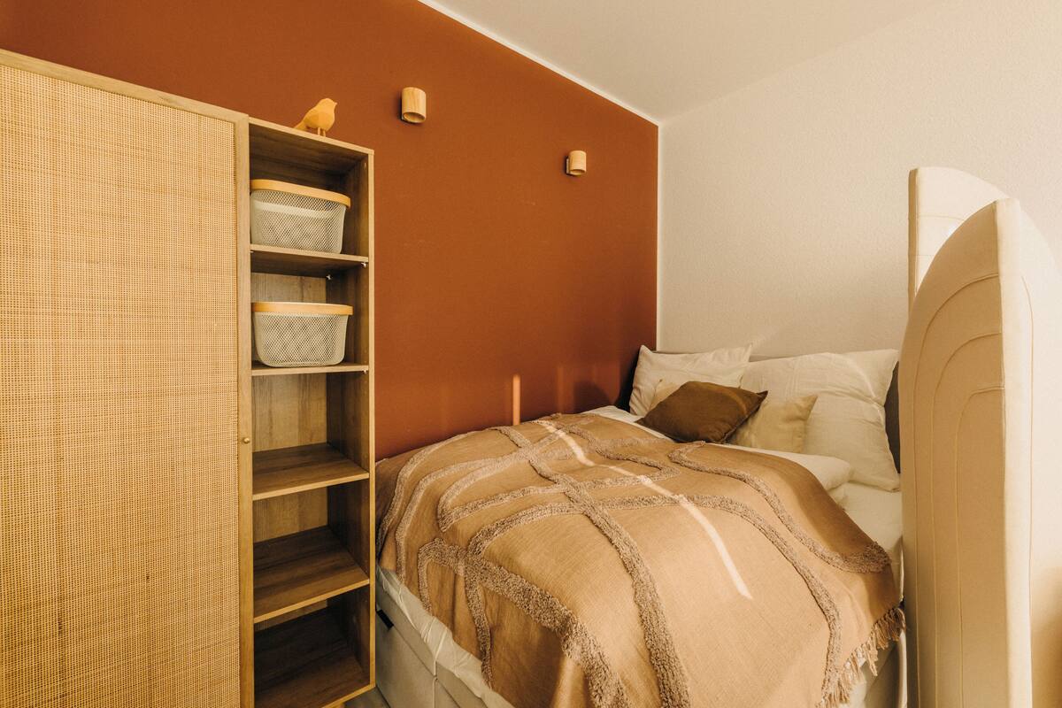 Una camera da letto con un letto, un armadio e una scaffalatura contenente cesti.