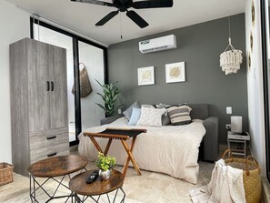A modern bedroom with a bed, bedside tables, a wardrobe, and a ceiling fan.
