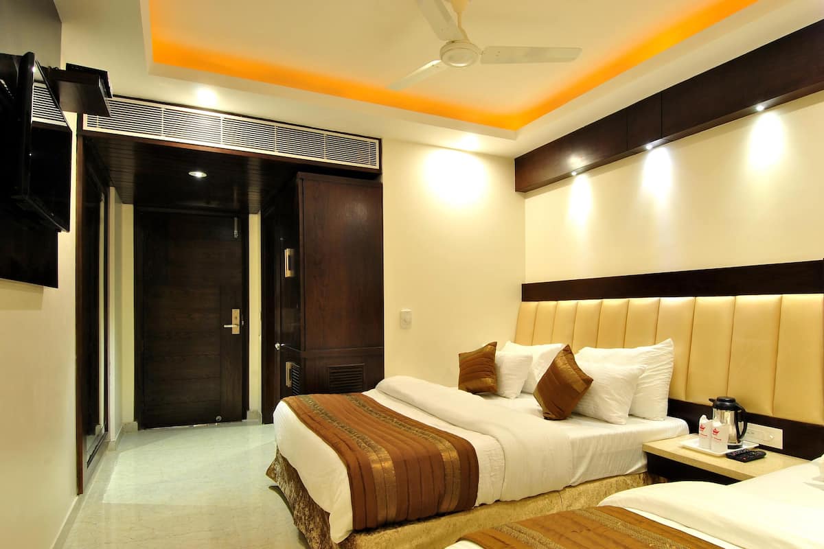 A hotel room with a bed, bedside table, and a ceiling fan.
