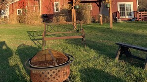 A red barn with a wooden porch and a metal pot in the foreground. - Charming pet friendly renovated barn with backyard, in Stevensville (Stevensville)
