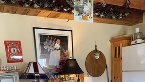 A kitchen with a wooden countertop, a red chair, a table with a Mickey Mouse design, a wine rack, and a refrigerator. - Charming pet friendly renovated barn with backyard, in Stevensville (Stevensville)