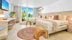 Habitación de hotel moderna con una cama grande, un escritorio, una silla y vistas al exterior.
