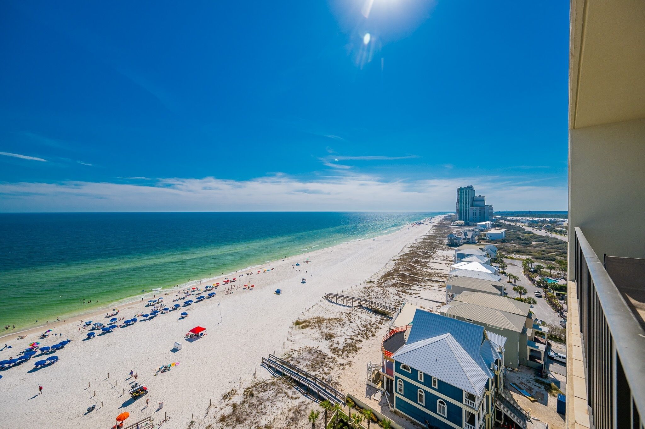 A beach with a clear view of the ocean and a high-rise building in the distance.