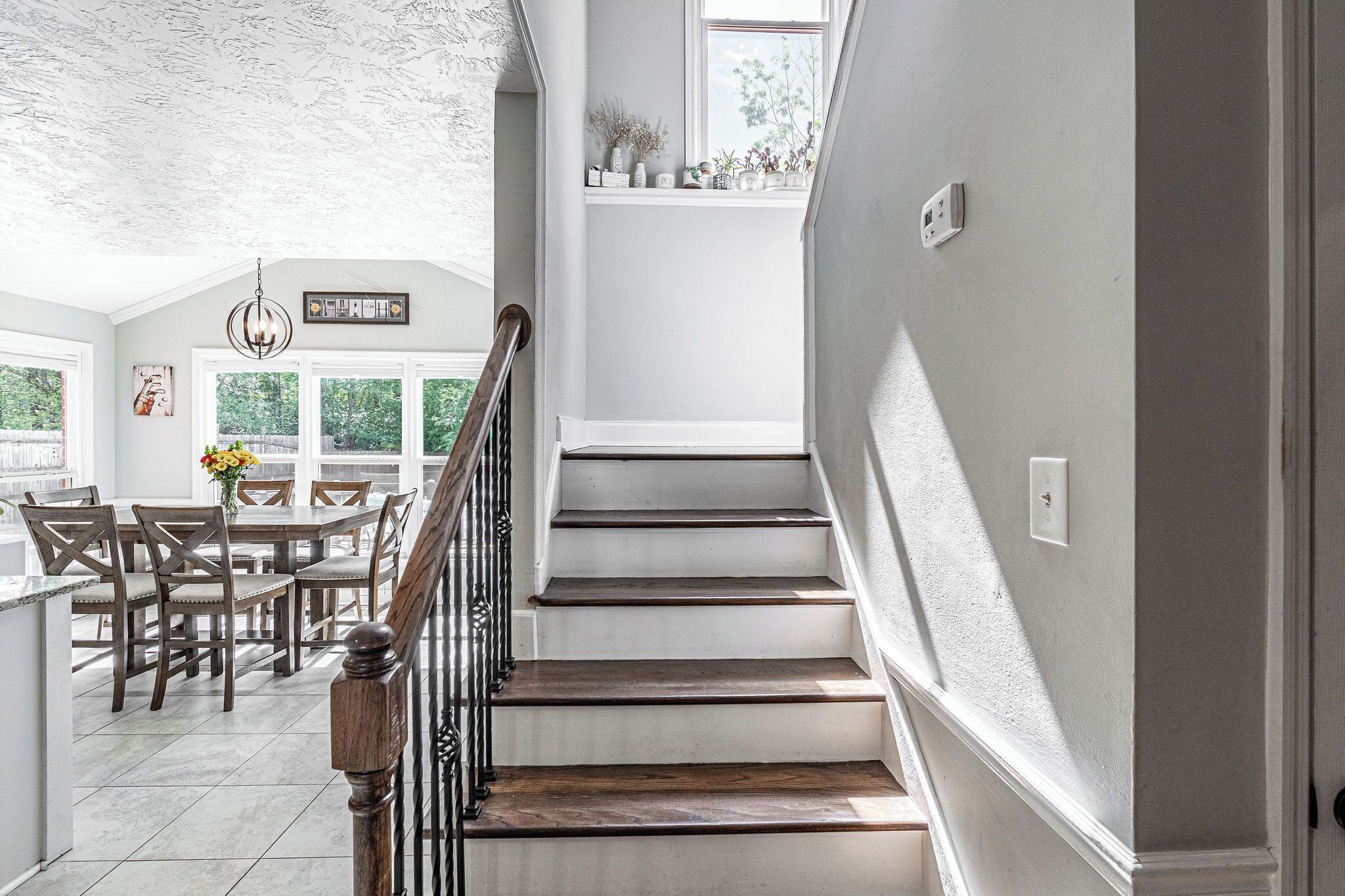 A staircase leading to a second floor with a dining area below.
