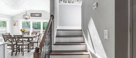 A staircase leading to a second floor with a dining area below.