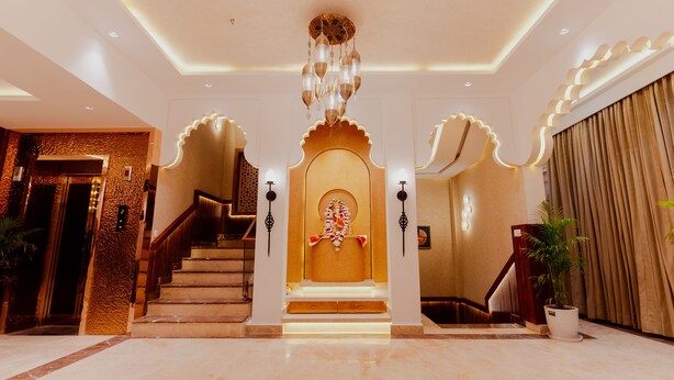 A grand entrance with a central statue, a staircase, and a chandelier. - Hotel Ratan Mahal (Datia)