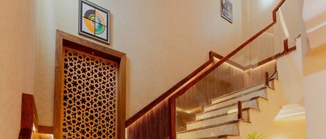 A staircase with wooden railings and a patterned wall panel.