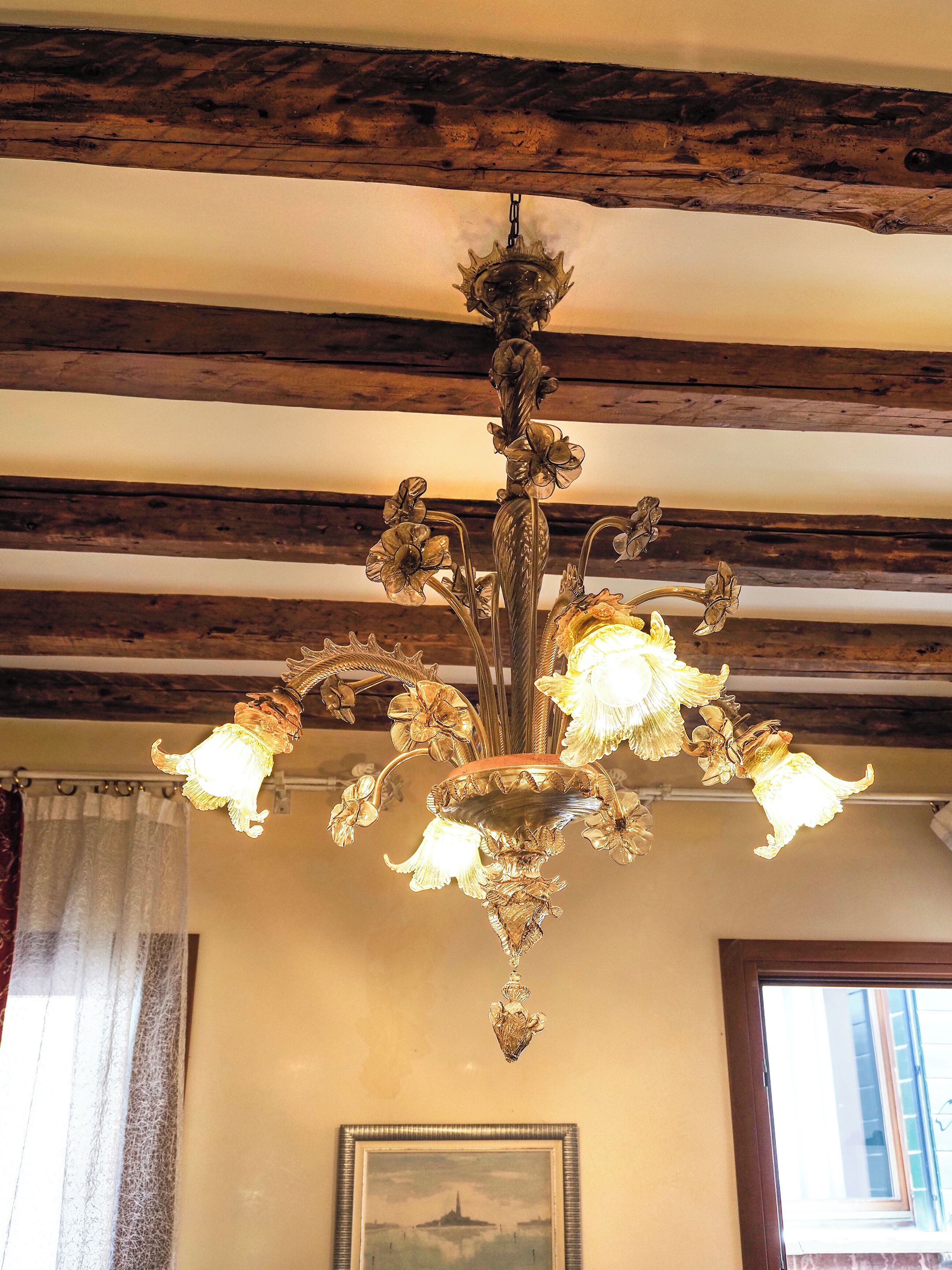 Un lampadario con diverse luci e un soffitto in legno.