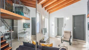 Un soggiorno moderno con una scala, una zona pranzo e un'ampia porta.