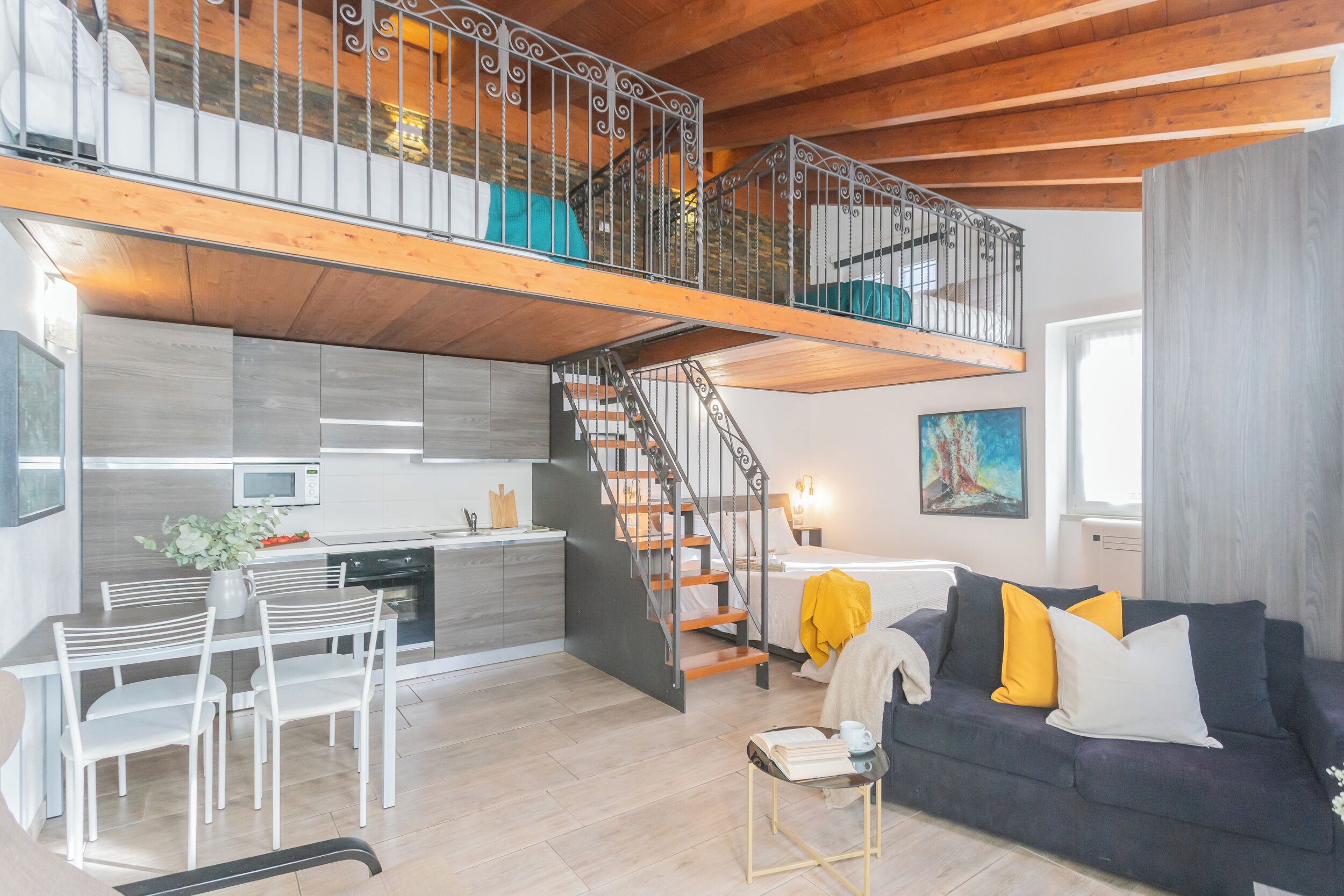 Un moderno apartamento tipo loft con entrepiso, cocina integrada, zona de comedor y una acogedora sala de estar.