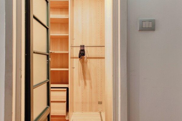 Een houten kast met verschillende planken en een kledingroede.