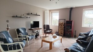 A living room with a TV, two armchairs, a sofa, a coffee table, and a fireplace. - 3-star rated house (sleeps 4) with private spa and garden (Bouvigny-Boyeffles)