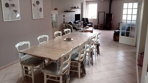 A dining area with a long table and chairs, a television, and a fireplace. - 3-star rated house (sleeps 4) with private spa and garden (Bouvigny-Boyeffles)