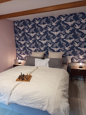 A bedroom with a bed, a chessboard, and a nightstand with a lamp. - House for 4 people with a private spa & recreational facilities (Bouvigny-Boyeffles)