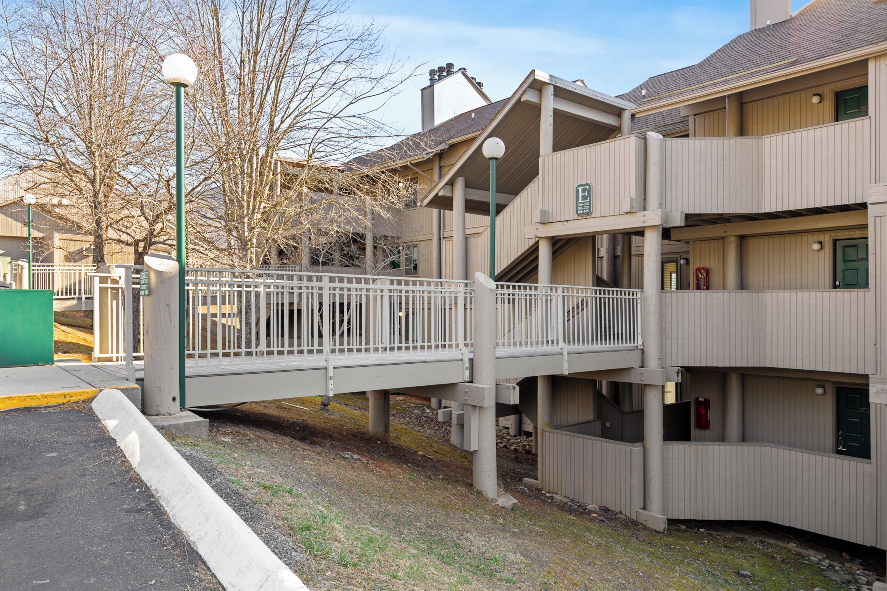 A multi-story building with a pedestrian bridge connecting two levels.