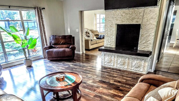 A living room with a ceiling fan, a fireplace, leather sofas, and a coffee table.