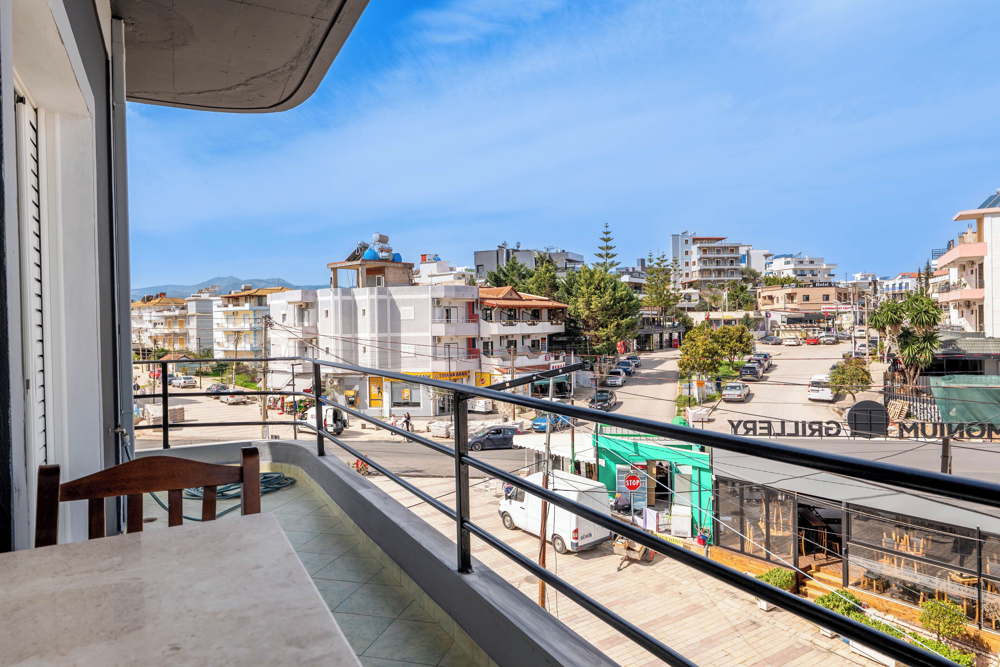 A balcony with a view of a cityscape, including buildings and a street.
