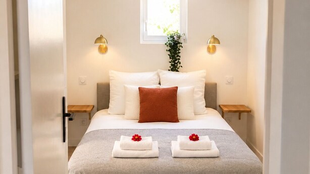 A bedroom with a bed, two bedside tables, a window, and a plant. - La Vie Douce - Between Ocean & Marshes (Saint-Michel-en-l'Herm)