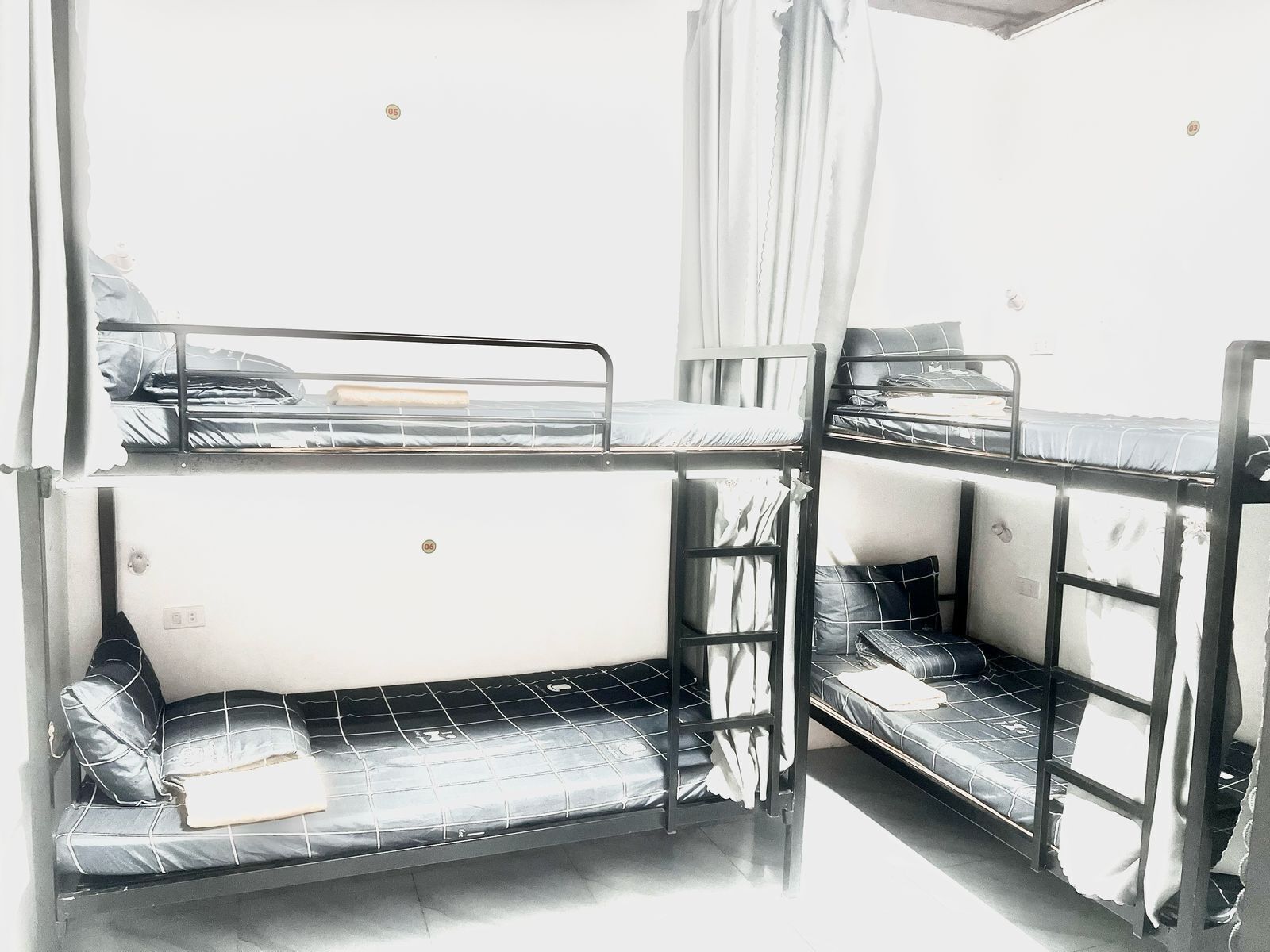 A bunk bed room with a window, a curtain, and a small table.