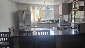 A compact kitchen with a central island, a refrigerator, and a sink.