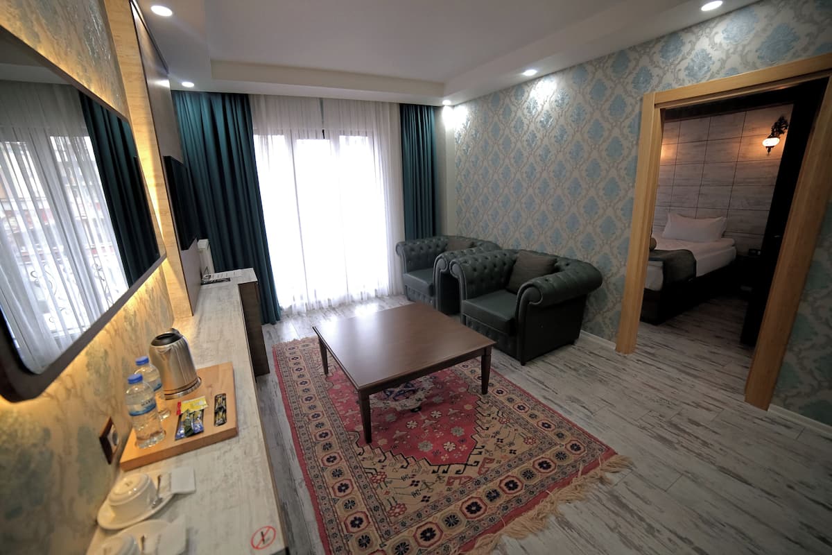 Una sala de estar con un sofá, una mesa de centro, una alfombra y un televisor.