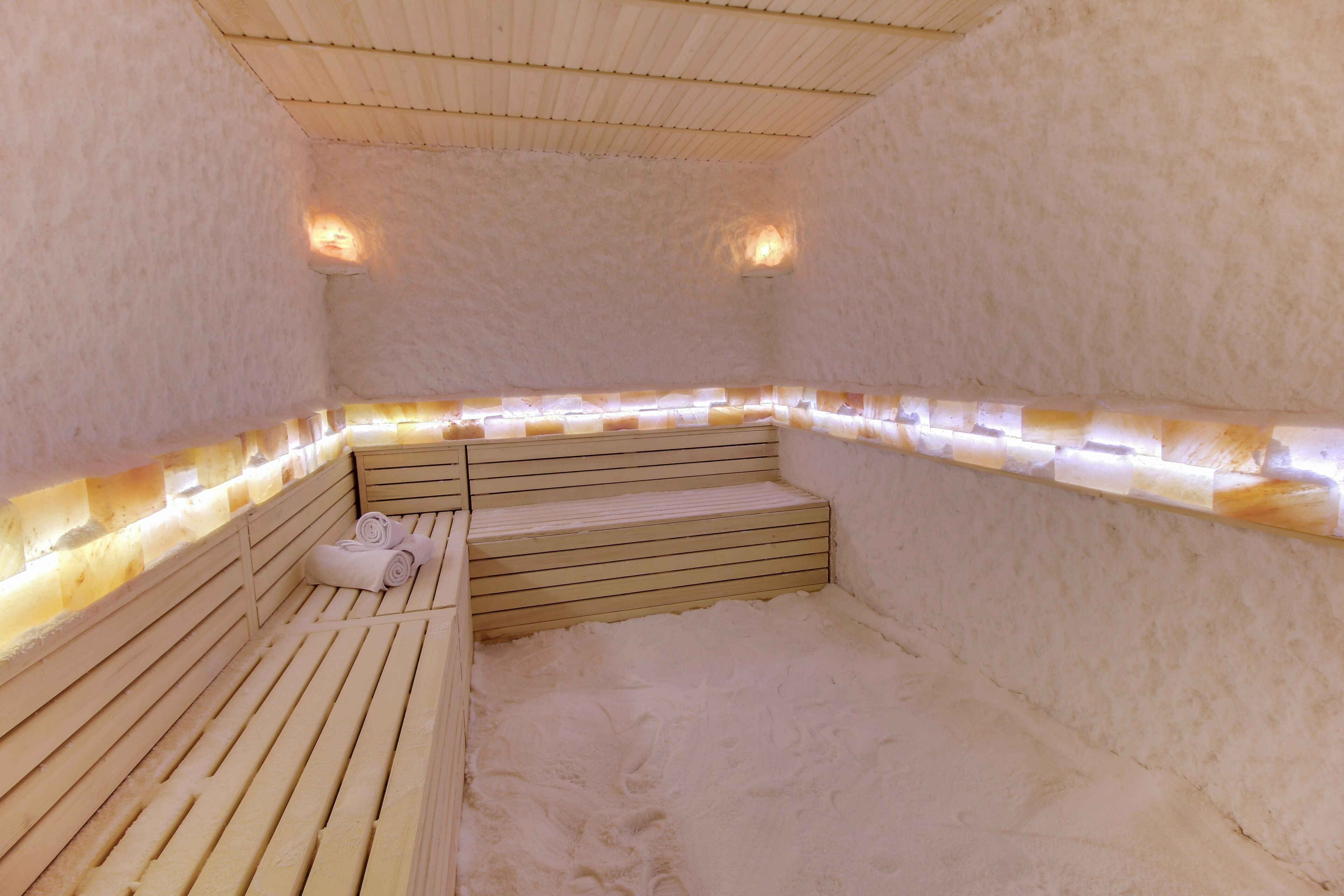 Una sauna con bancos de madera, rodeada de paredes cubiertas de nieve.