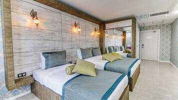 Habitación de hotel con dos camas, cabecero de madera, apliques de pared y un espejo grande.
