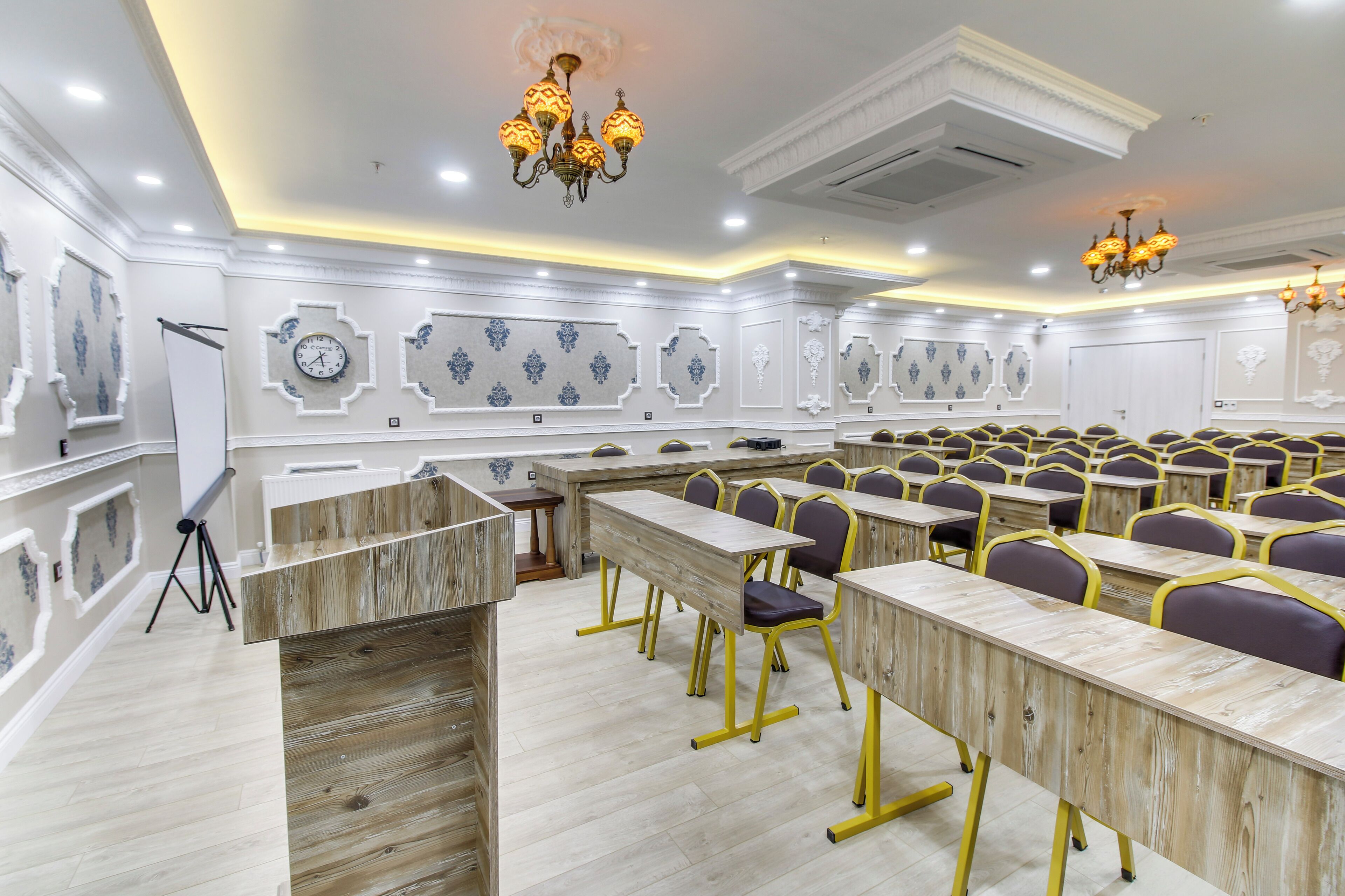 A conference room with wooden desks, purple chairs, and decorative wall panels.