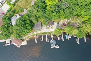 Enjoy serene lakeside views from the dock, surrounded by lush greenery and a well-maintained lawn.