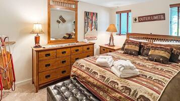 A bedroom with a large bed, a wooden dresser, a mirror, and a sign indicating 'Outer Limits'.