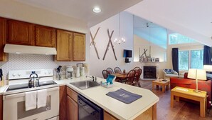 Una cocina moderna con armarios de madera, estufa integrada y un comedor con chimenea.
