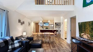 A modern apartment with a dining area, kitchen, and living room. - Woods Village 43 (Killington)