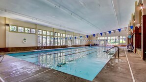 En inomhuspool med tydliga banor, en livräddarstol och en flytväst som hänger på väggen.
