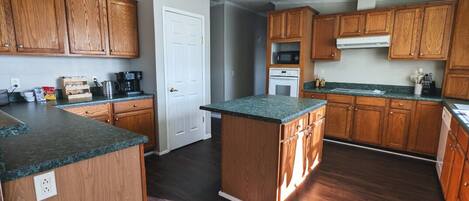 A kitchen with wooden cabinets, a central island, and a microwave.