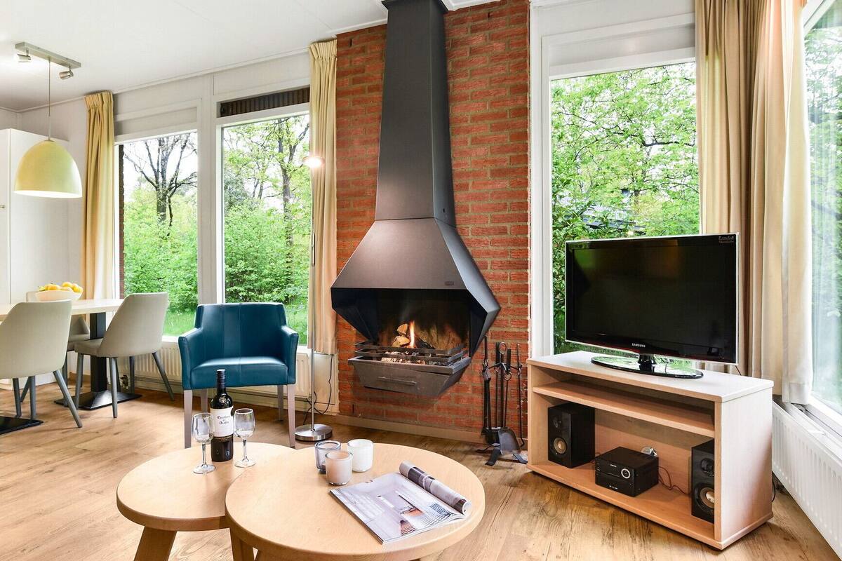 A modern living room with a fireplace, a dining area, and a TV.