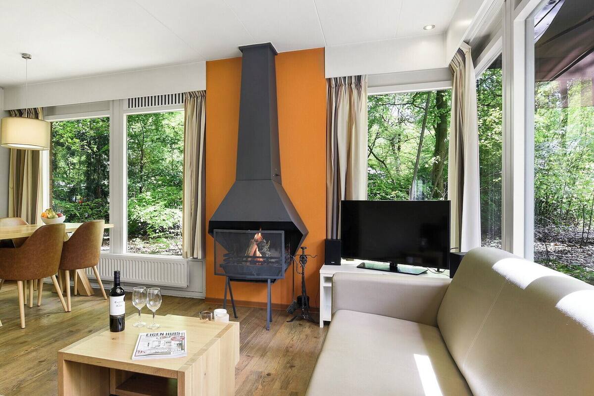 A modern living room with a fireplace, a dining area, and a sofa.