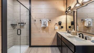 Une salle de bain moderne avec une douche à parois de verre, des murs recouverts de panneaux en bois et un grand miroir au-dessus du lavabo.