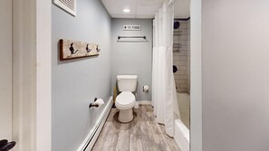A bathroom with a toilet, a shower, a towel rack, and a sign indicating 'The Plunge'. - Treehouse Home (Ludlow)
