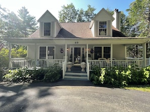 A two-story house with a porch, number 69, surrounded by greenery. - Harbor Hideaway (York)