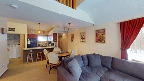 A compact living space with a kitchenette, a dining area, and a seating area. - Woods Village 33 (Killington)
