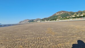 A beach with sand, a shadow, and distant mountains. - Stunning Sea View Blue Haven in Penmaenmawr (Penmaenmawr)