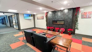 A conference room with a long table, black chairs, and red potted plants. - Mt Green 1-b01 (Killington)