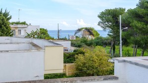 A residential area with a view of the sea, featuring modern buildings and lush greenery. - Alla Rosa Dei Venti Sud Wind House (Torre Specchia Ruggeri)
