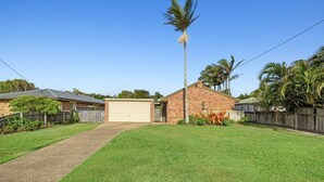 A residential property with a brick house, a garage, and a well-maintained lawn.
